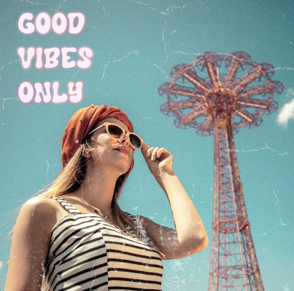 Woman wearing striped top and sunglasses standing below a festival ride