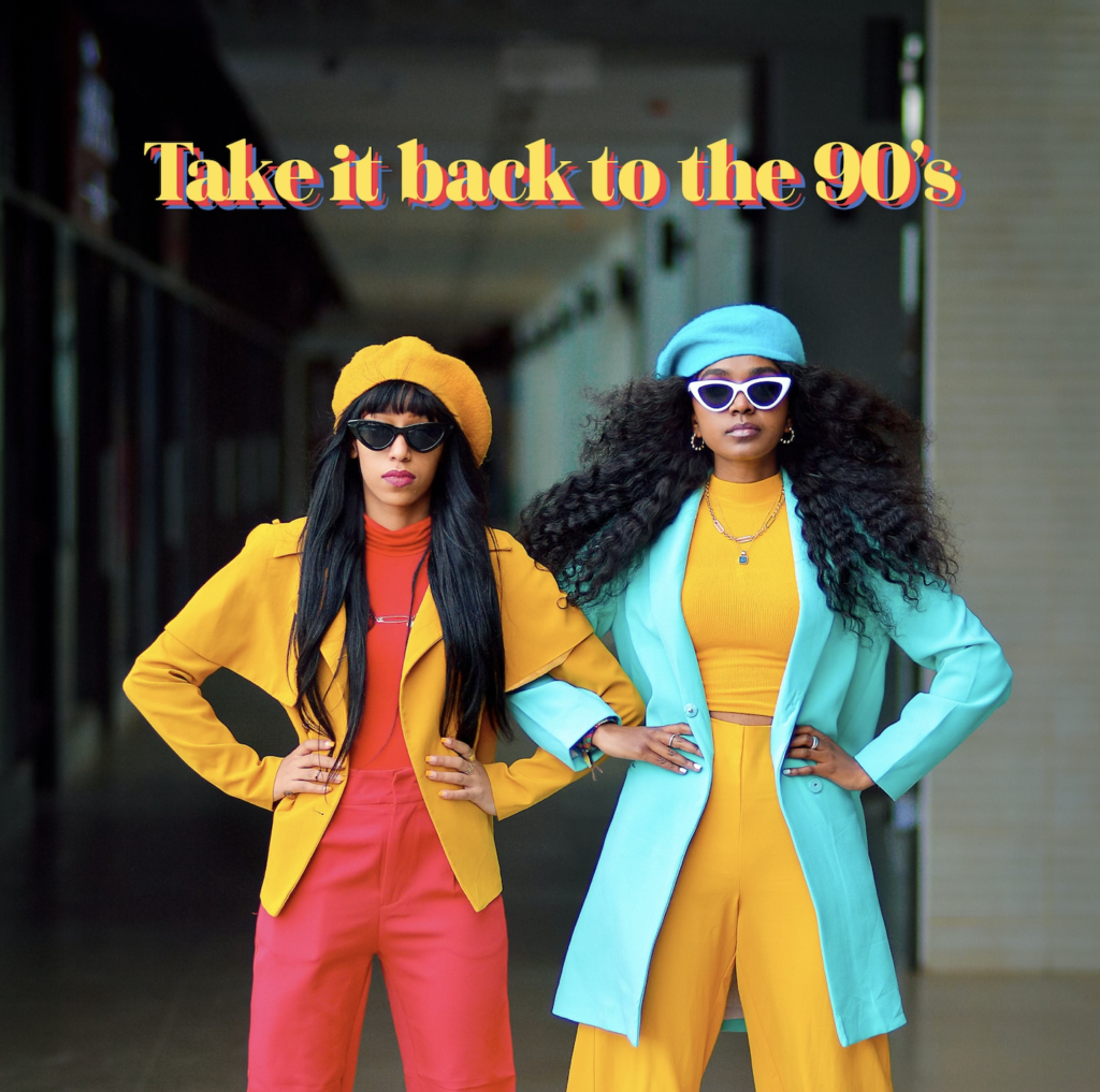Two women wearing brightly colored suits with sunglasses and hats