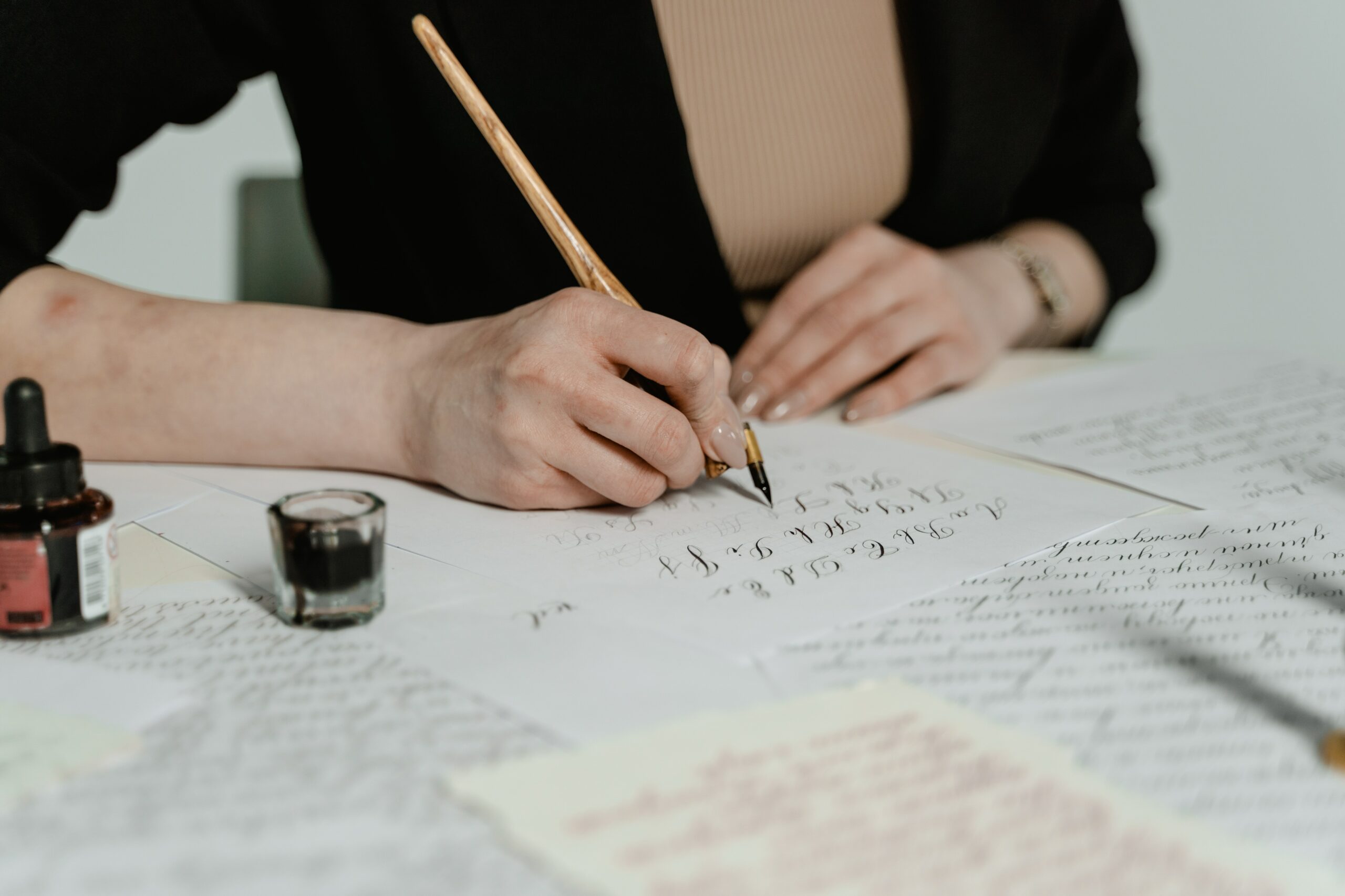 Woman seated at a desk doing calligraphy