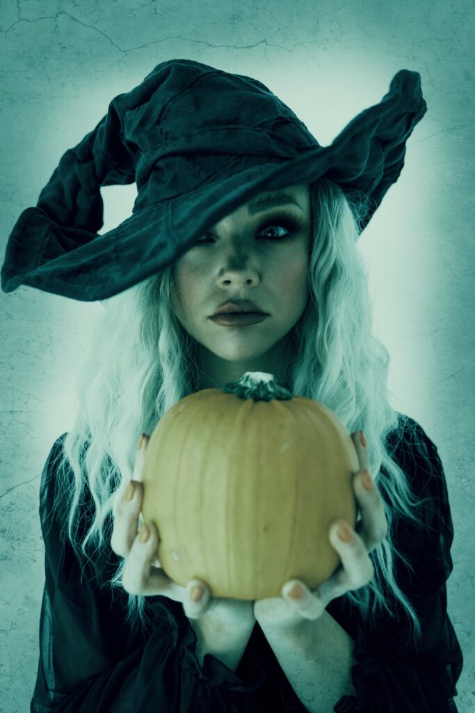 Woman dressed as a witch holding a pumpkin